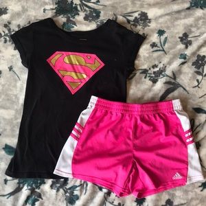 Black shirt with a pink and gold superman logo